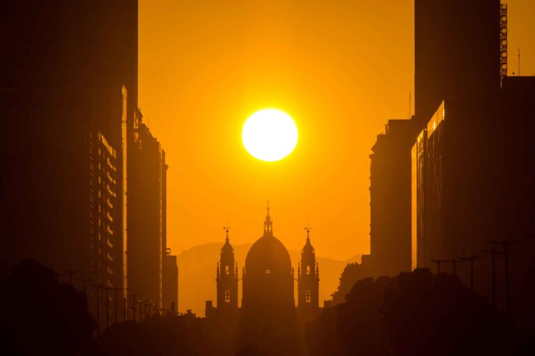 Silhueta da Igreja da Candelária com o sol entre os prédios do Centro